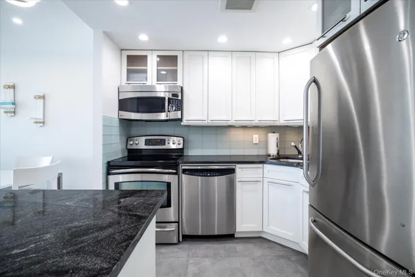 a kitchen with stainless steel appliances a stove microwave and refrigerator