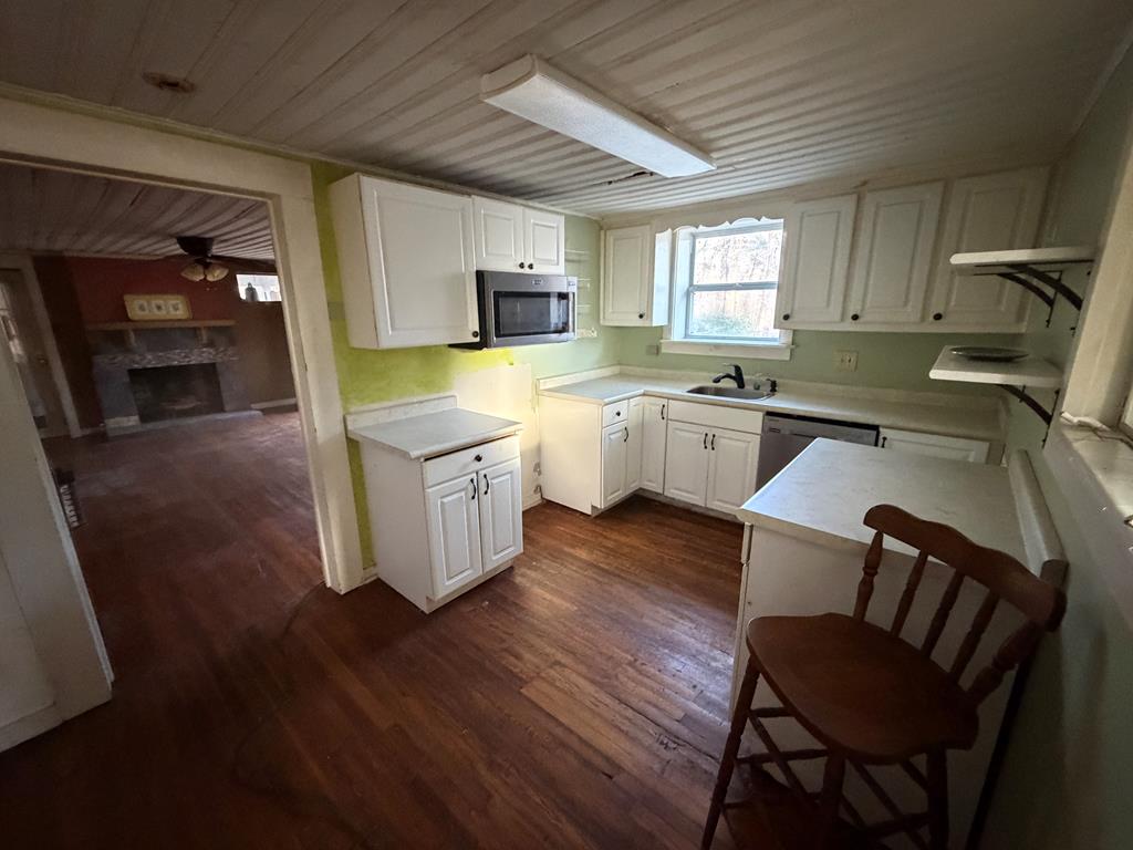 316 Lake Drive Morganton, GA 30560 - Photo 15 of 41 a kitchen with cabinets a sink dishwasher and a stove with wooden floor