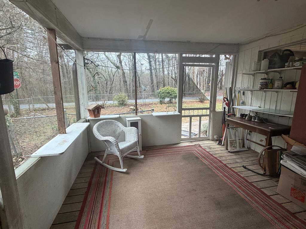 316 Lake Drive Morganton, GA 30560 - Photo 23 of 41 a living room with furniture a flat screen tv and a floor to ceiling window
