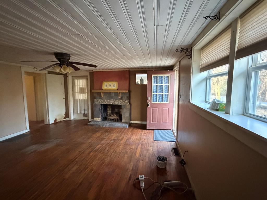 316 Lake Drive Morganton, GA 30560 - Photo 32 of 41 an empty room with windows a fireplace and wooden floor