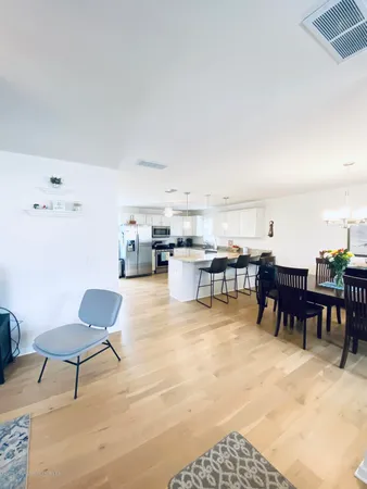 a living room with furniture and a dining table with kitchen view