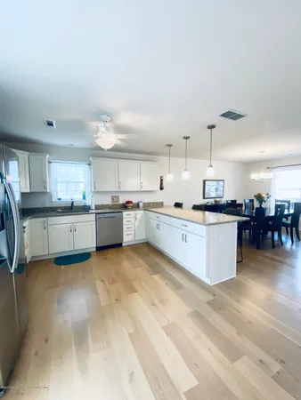 a large kitchen with a lot of white cabinets and stainless steel appliances