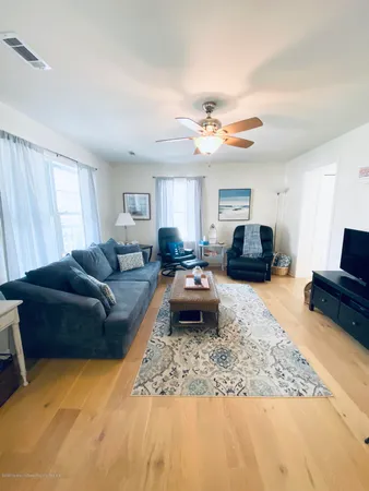 a living room with furniture a couch and wooden floor
