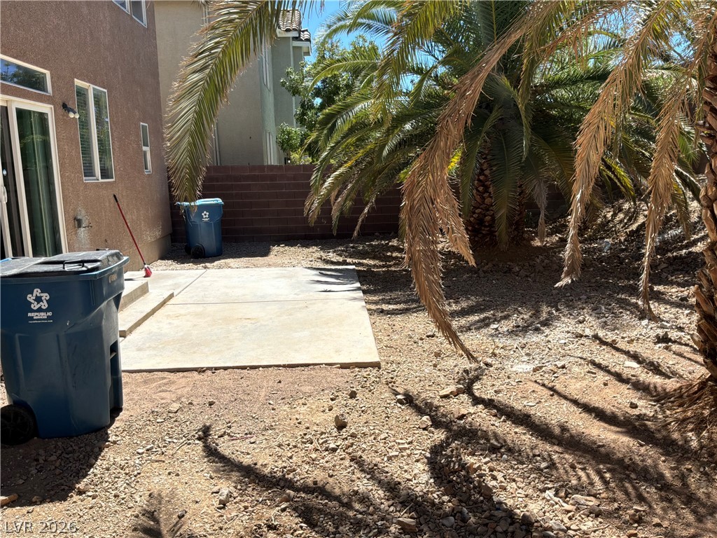 9041 Rendon Street Las Vegas, NV 89143 - Photo 33 of 34 Mature palm trees shade a private concrete patio area.