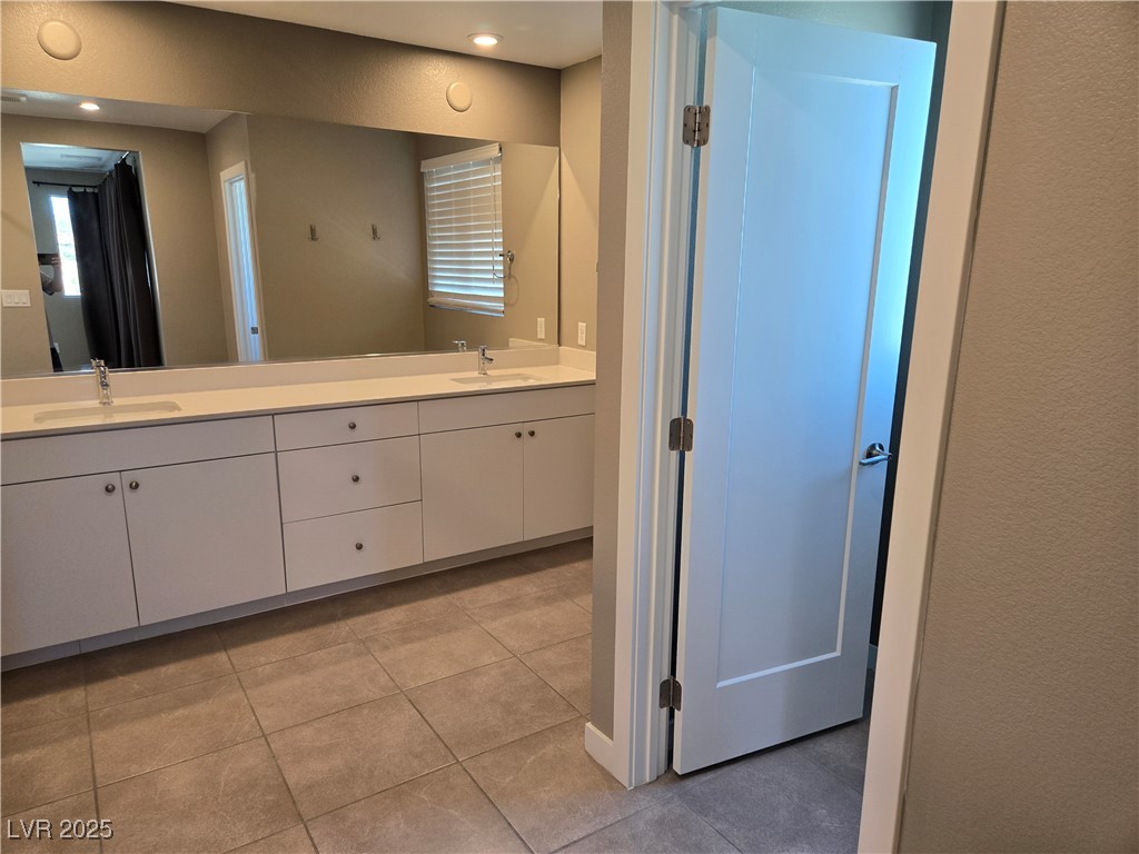 3192 Timorasso Avenue Henderson, NV 89044 - Photo 8 of 16 Bathroom with double vanity, light tile patterned floors, and a textured wall