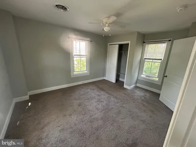 an empty room with windows and closet
