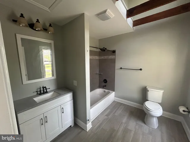 a spacious bathroom with a toilet sink and mirror