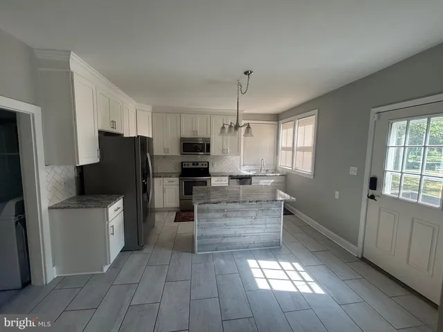 a large kitchen with cabinets and stainless steel appliances