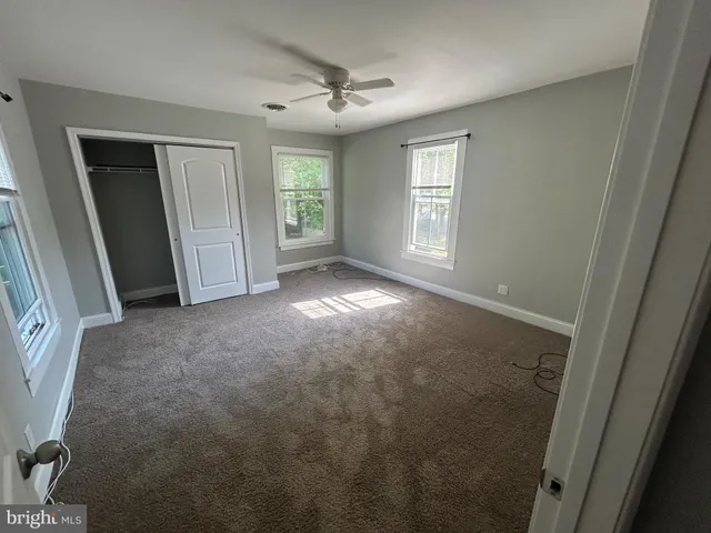 an empty room with windows and closet