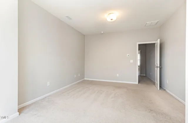 an empty room with closet and a bathroom