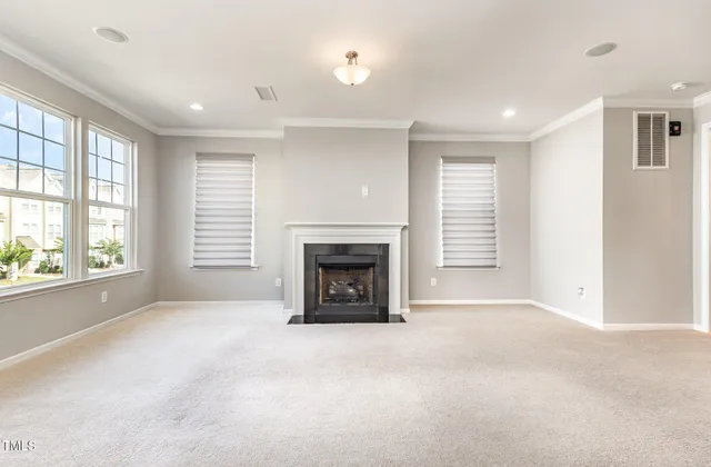 a view of an empty room with a fireplace and a window