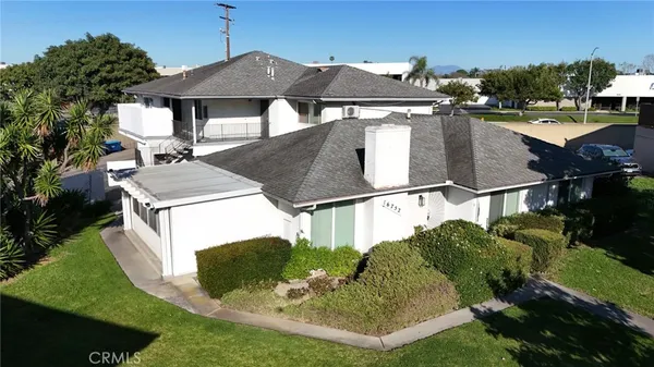 a view of a white house with a yard and potted plants