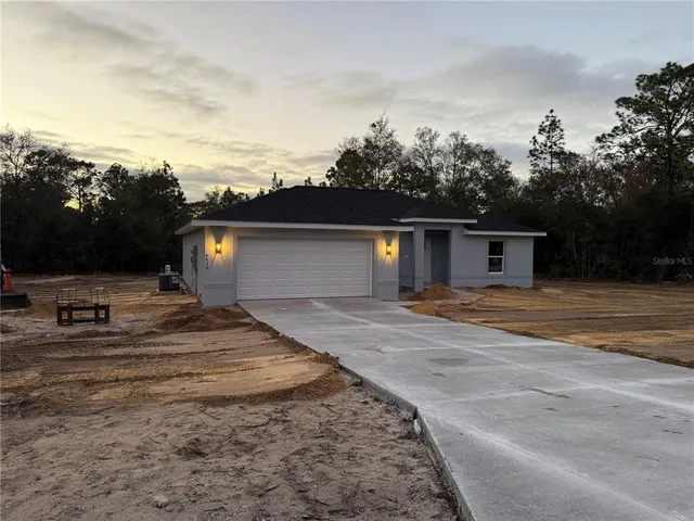 a view of a house with car parked on road