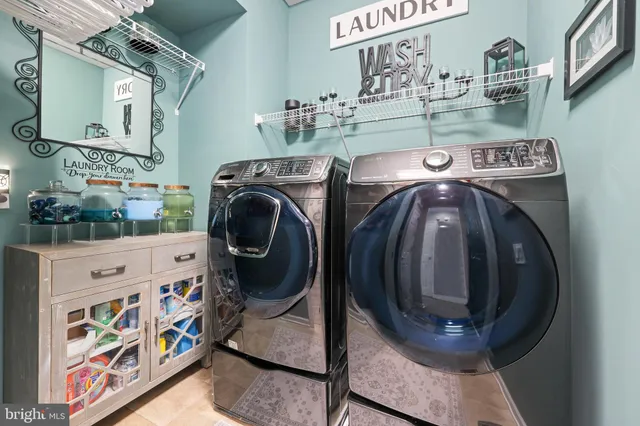 a living room with furniture kitchen view and a chandelier