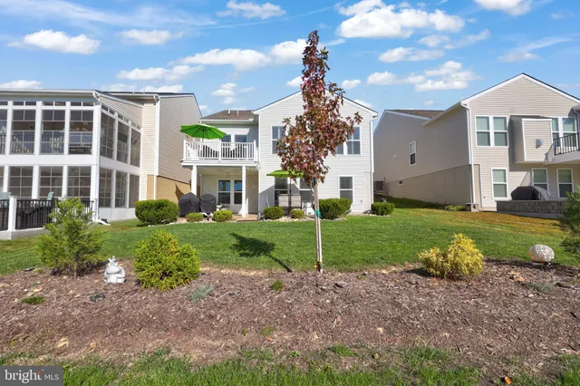 a view of a white house with a yard and potted plants