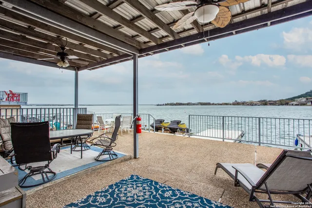 a view of a balcony with chairs and wooden floor