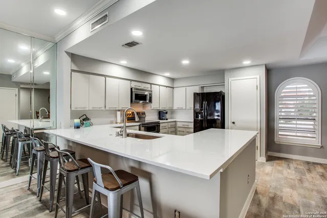 a large kitchen with kitchen island a table and chairs