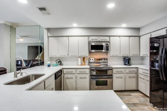 a kitchen with a sink stove top oven and refrigerator