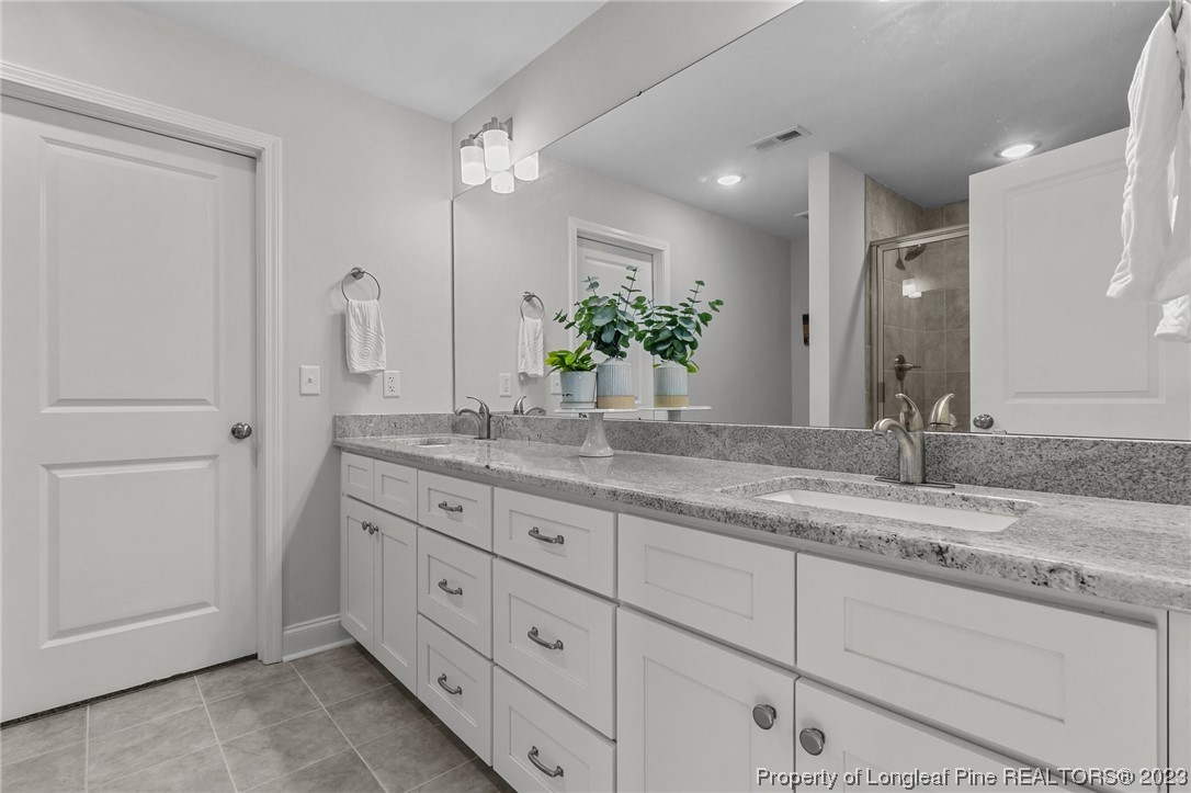 445 Myra Road Raeford, NC 28376 - Photo 25 of 45 a bathroom with a granite countertop sink and a mirror