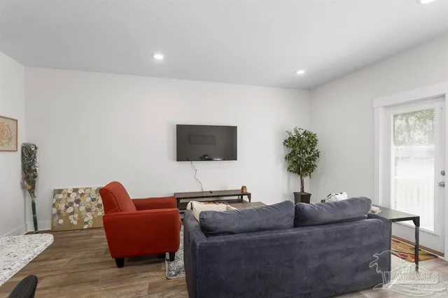 a living room with furniture a window and a flat screen tv