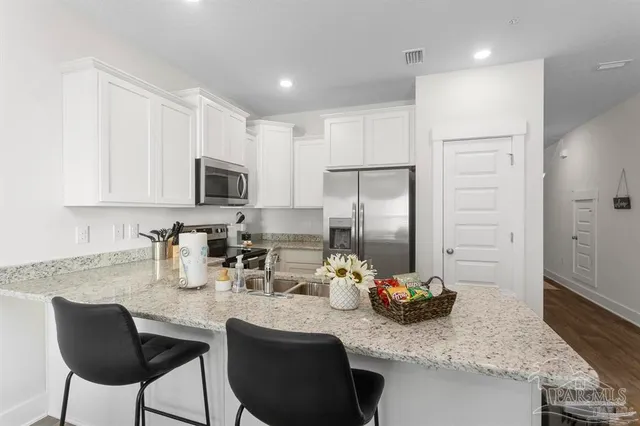 a kitchen with stainless steel appliances granite countertop a refrigerator a stove a sink and dishwasher