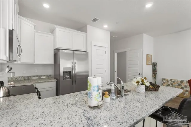 a kitchen with stainless steel appliances granite countertop a sink dishwasher stove top oven and refrigerator