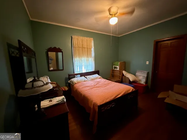 a bedroom with a bed and a flat tv screen on dresser