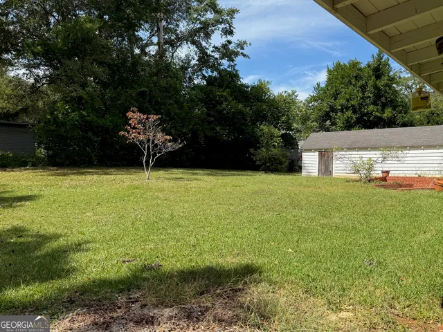 a view of a house with backyard and sitting area