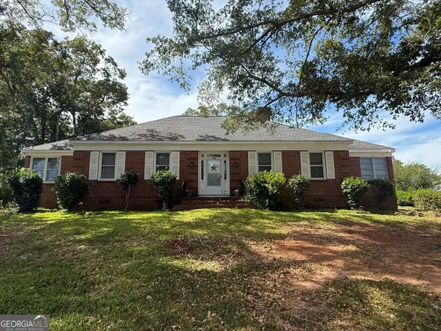 a view of a house with a tree in front of it