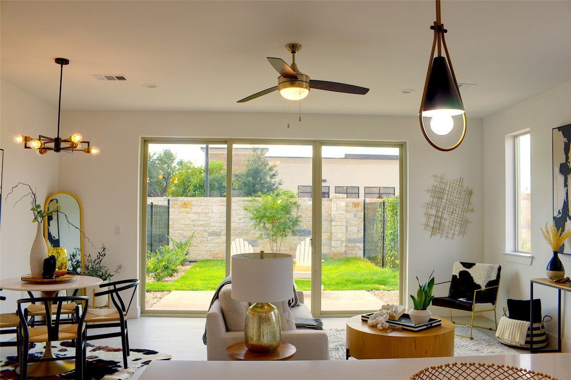 300 Tesla Circle Austin, TX 78681 - Photo 8 of 39 Living area featuring ceiling fan, wood finished floors, and a chandelier