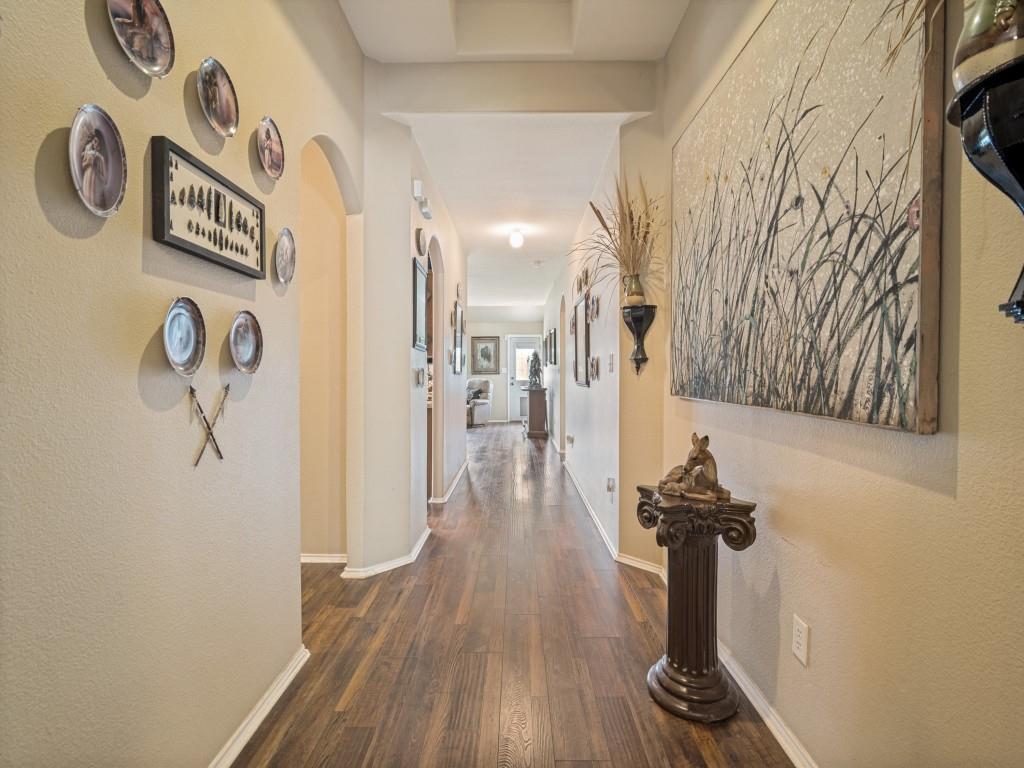 119 Robin Lane Forney, TX 75126 - Photo 5 of 27 Long hallway featuring wood-finish flooring, light-toned walls, and arched doorways