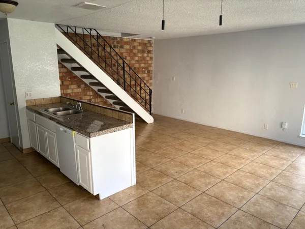 a kitchen with granite countertop a sink and a stove