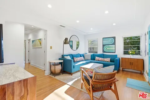 a living room with furniture a rug and a window