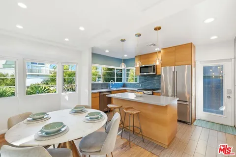 a kitchen with stainless steel appliances granite countertop a sink a stove and a refrigerator