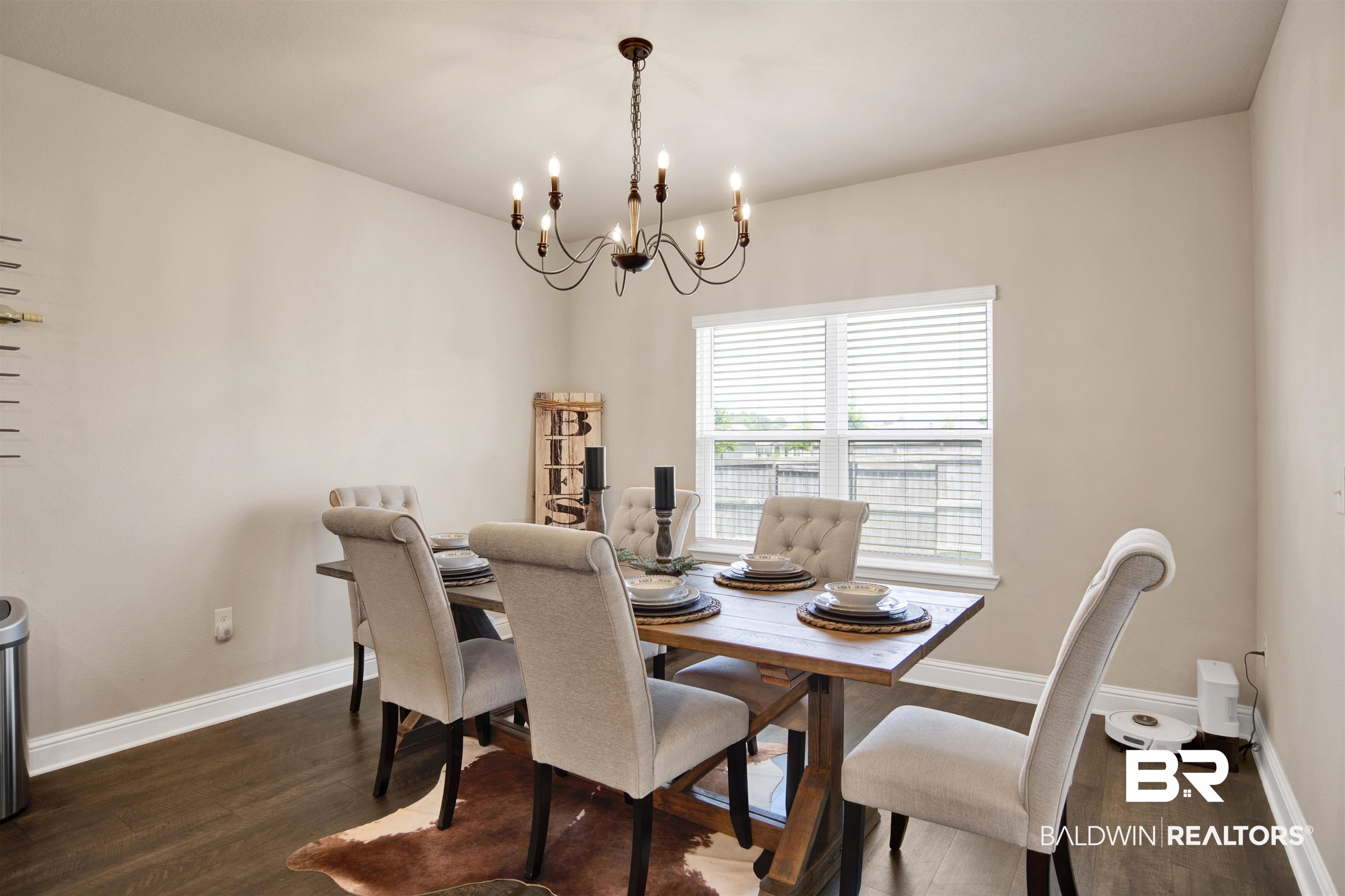 8493 Bronze Lane Foley, AL 36535 - Photo 15 of 38 Dining space featuring wood-finish flooring, a contemporary chandelier, and a window with horizontal blinds