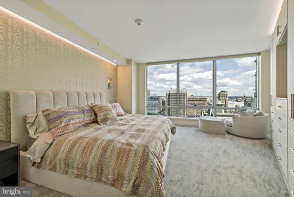 a spacious bedroom with a bed and a large window