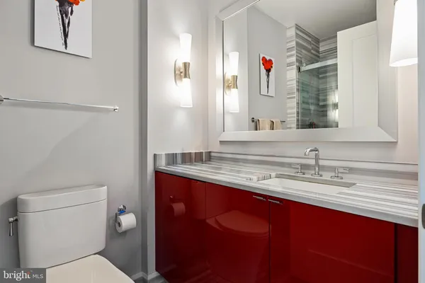 a bathroom with a granite countertop sink a toilet and a mirror