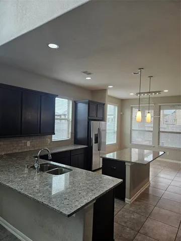 a large kitchen with kitchen island a sink stainless steel appliances and a counter space