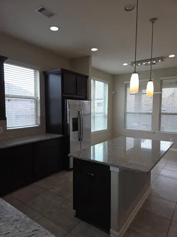 a kitchen with granite countertop a refrigerator and window