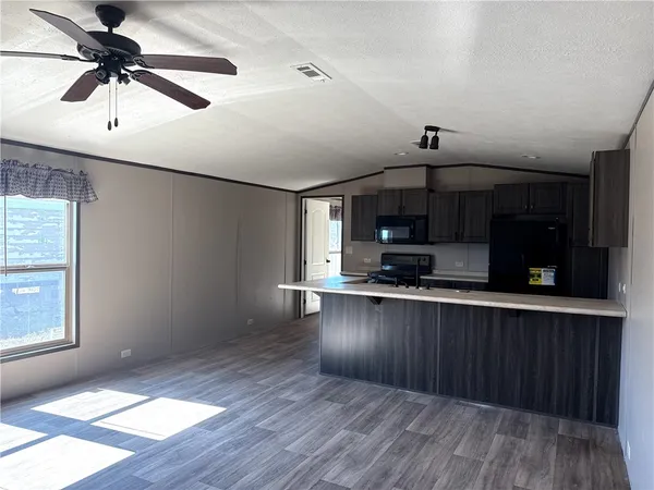 a kitchen with stainless steel appliances granite countertop a sink a stove and a wooden floors
