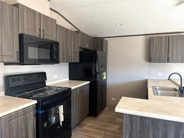 a kitchen with stainless steel appliances a stove microwave and sink