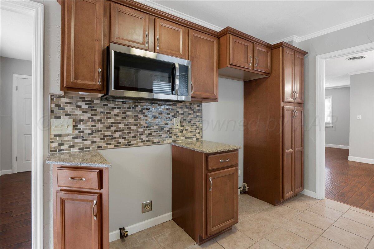 1415 Southwest 34th Avenue Amarillo, TX 79109 - Photo 9 of 22 a kitchen with stainless steel appliances granite countertop a refrigerator and a microwave
