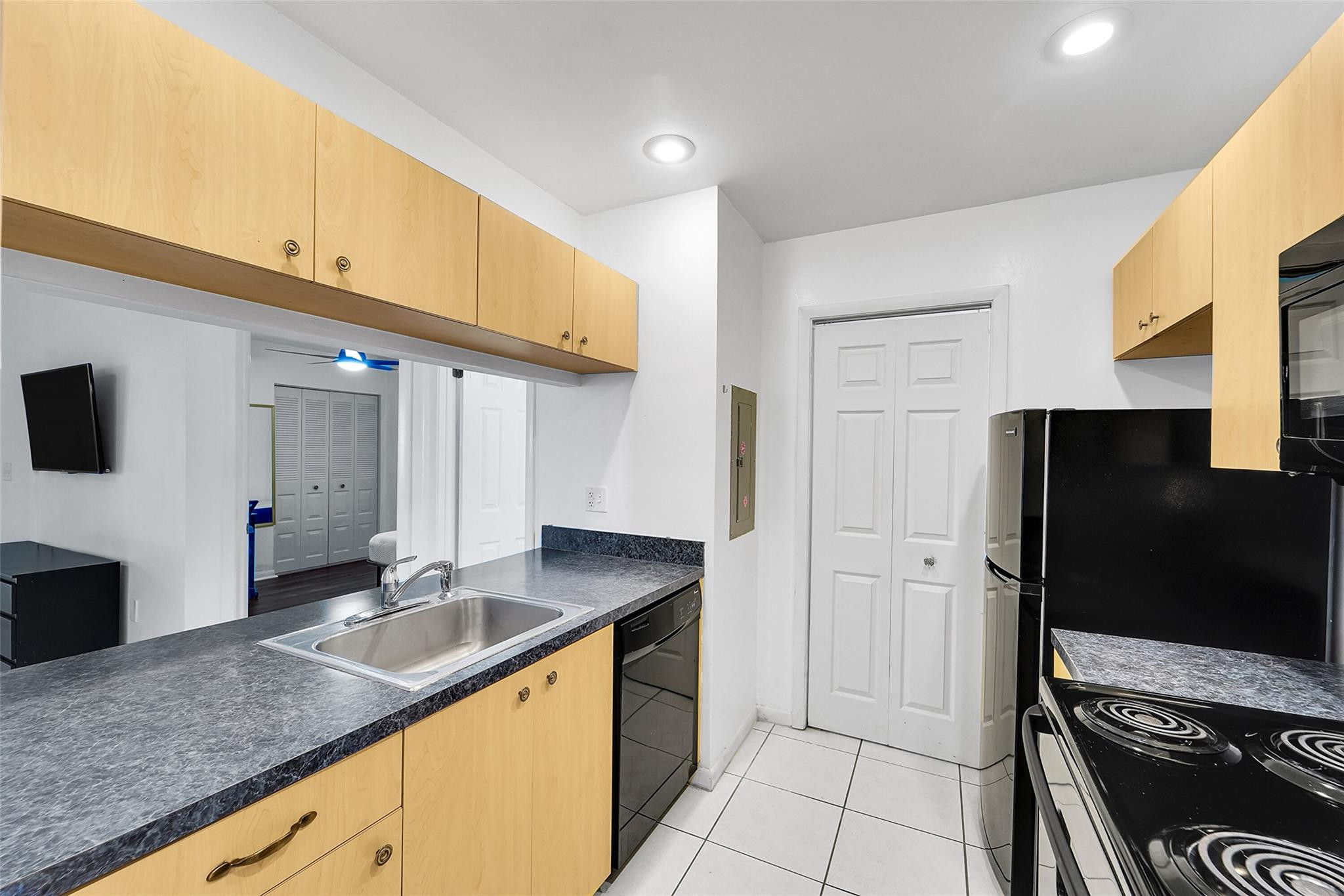2698 North Nob Hill Road Sunrise, FL 33322 - Photo 6 of 27 a kitchen with granite countertop a refrigerator and a sink
