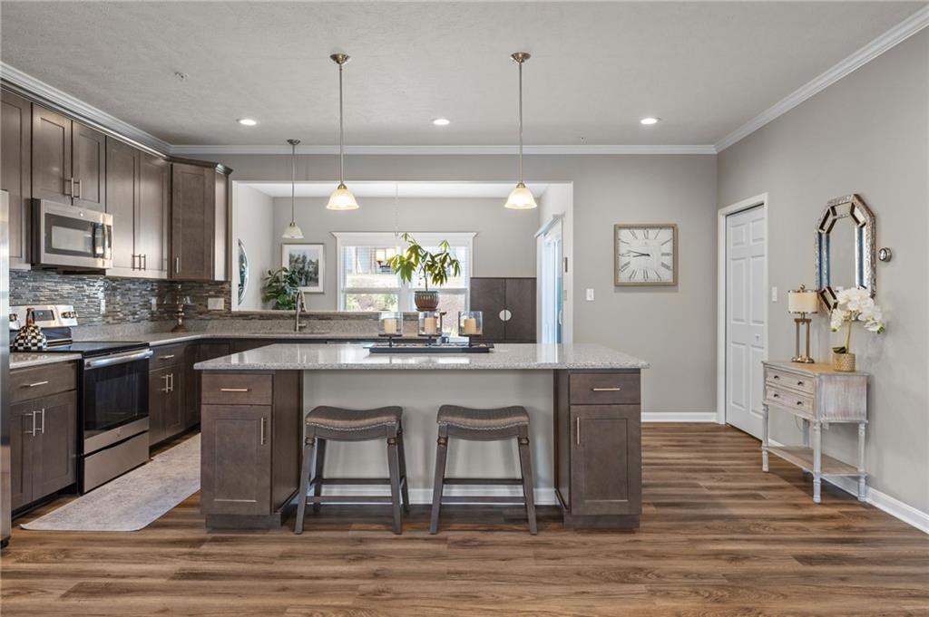 217 Lockheed Drive Coraopolis, PA 15108 - Photo 3 of 27 a kitchen with stainless steel appliances granite countertop a stove top oven a sink dishwasher a dining table and chairs with wooden floor