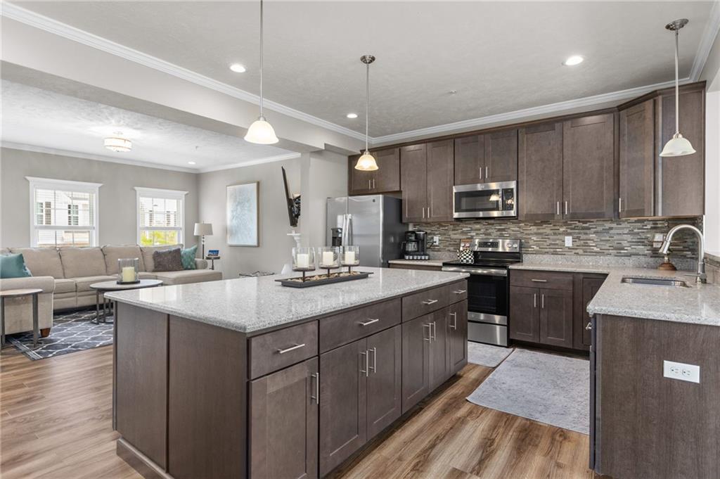 217 Lockheed Drive Coraopolis, PA 15108 - Photo 4 of 27 a kitchen with kitchen island granite countertop a sink stove and cabinets
