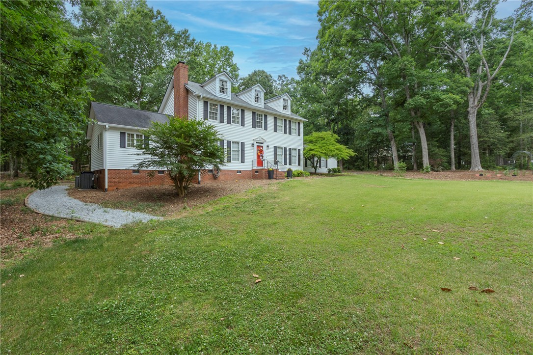 203 Oak Hollow Pendleton, SC 29670 - Photo 50 of 50 A classic colonial facade stands gracefully amidst verdant trees and an expansive lawn.