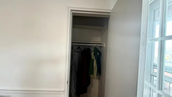 a view of walk in closet with clothes