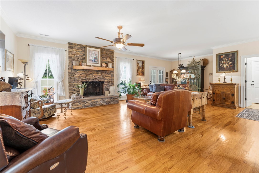 160 Sentell Road Williamston, SC 29697 - Photo 10 of 45 Rich hardwood floors complement a full stone fireplace, creating a cozy and elegant gathering space.