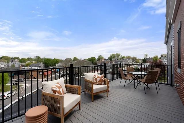 a balcony with wooden floor and outdoor seating