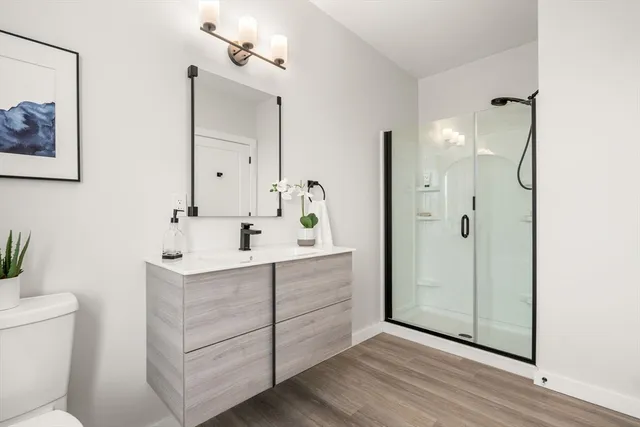 a bathroom with a double vanity sink mirror and toilet